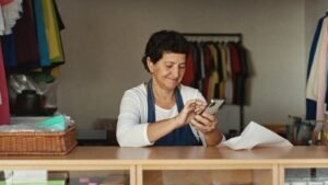 Lojista conferindo no celular os contatos vindos de uma campanha